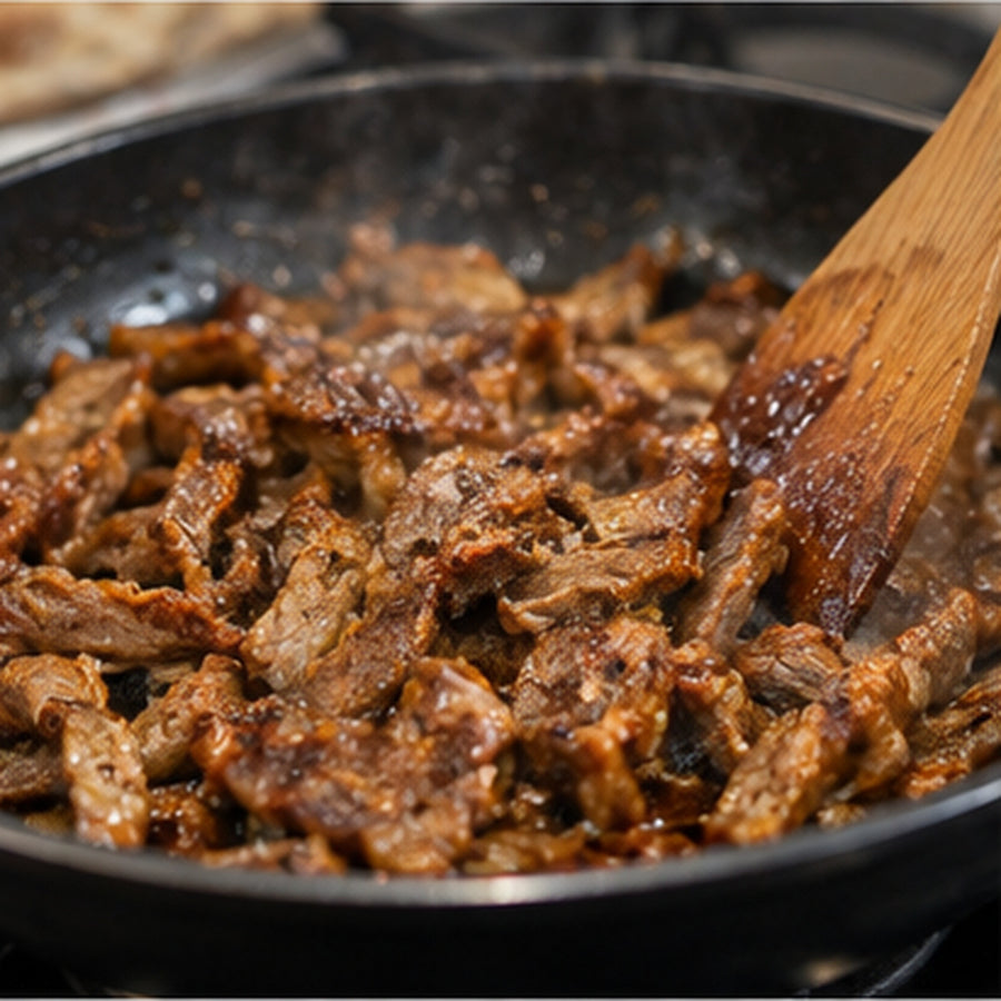 Opékání nakrájeného masa na pánvi při přípravě döner kebabu