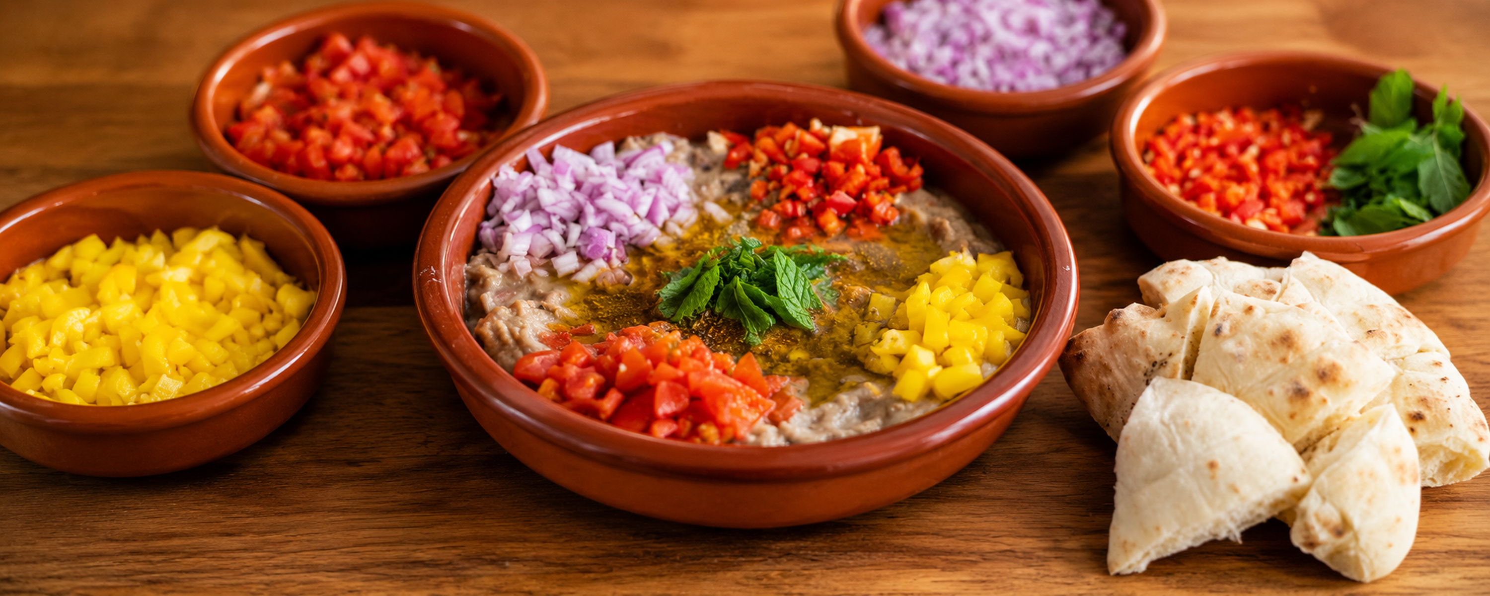 Egyptský Ful Medames s fava fazolemi, rajčaty, paprikou, cibulí, mátou a pita chlebem