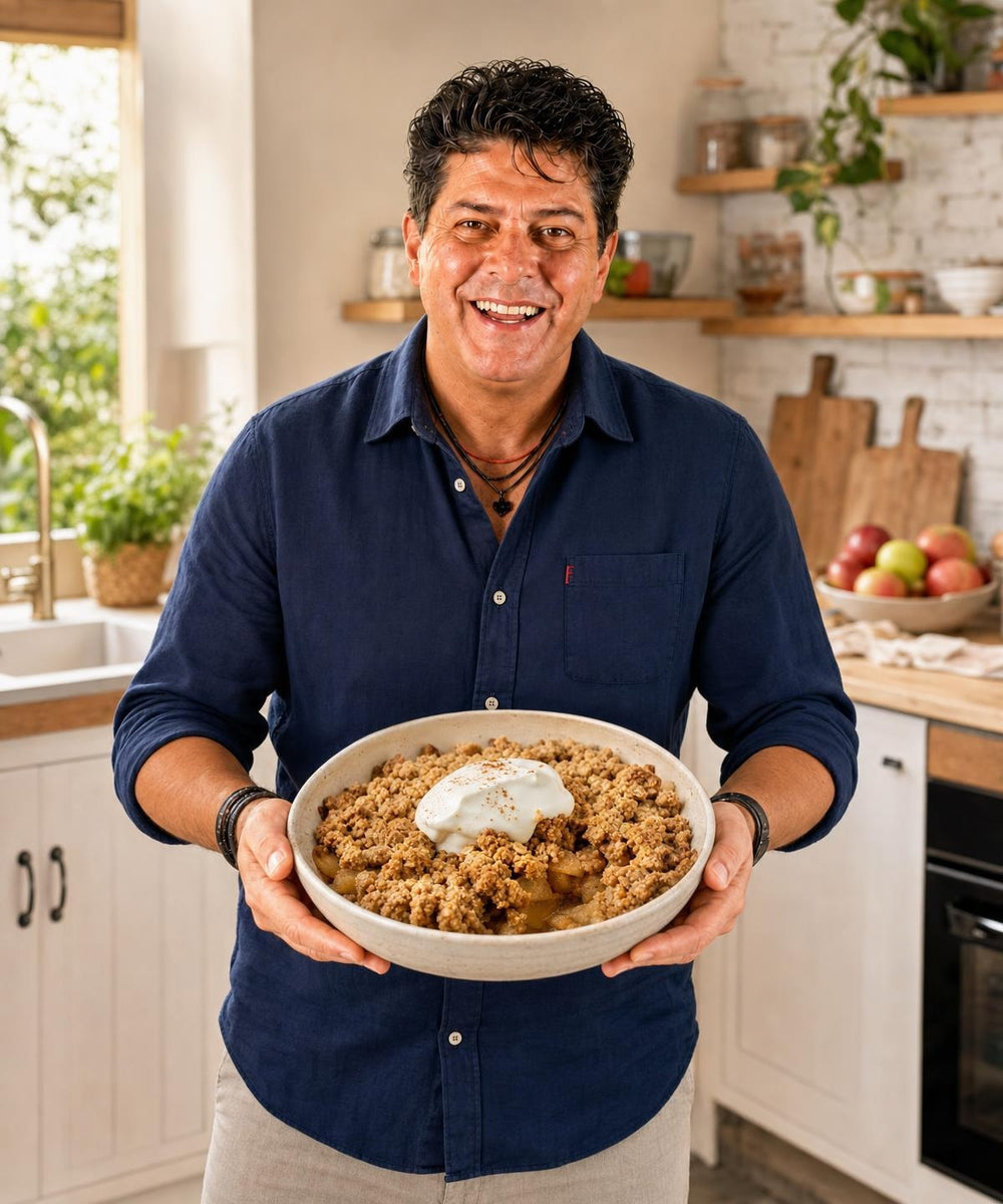 Majkl drží hotový pokrm Jablečný proteinový crumble bez lepku a usmívá se do kamery.