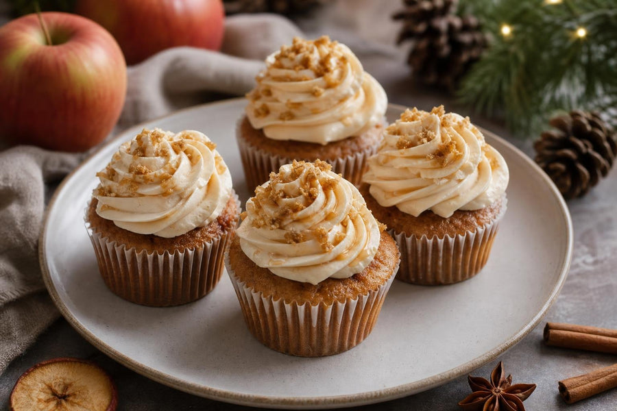 Naservírovaný recept Jablečné cupcakes s vánočním kořením a máslovým javorovým krémem na stole.