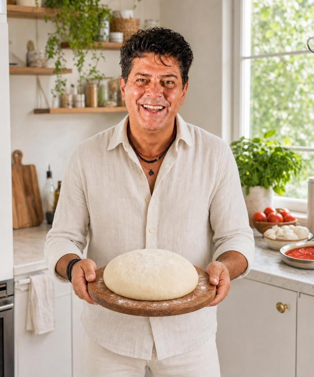 Majkl drží hotový pokrm Originální italské těsto na pizzu a usmívá se do kamery.