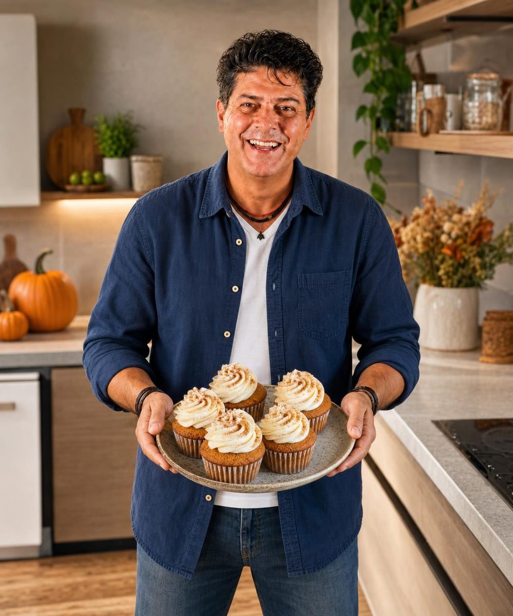 Majkl drží hotový pokrm Dýňové cupcakes s pumpkin spice a usmívá se do kamery.