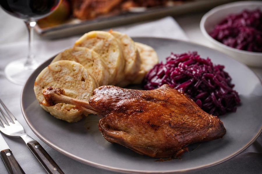 Naservírovaný recept Svatomartinská husa s červeným zelím a bramborovým knedlíkem na stole.